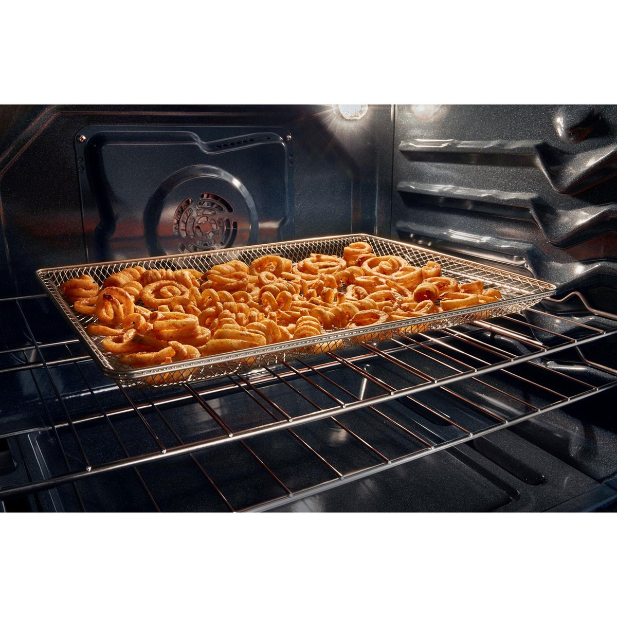 Air fry basket with curly fries inside the oven, fan visible for air cooking.