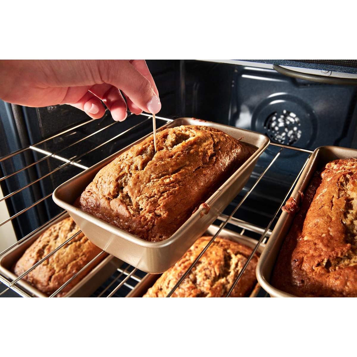 Multiple loaves baking on two racks with convection fan at back of oven.