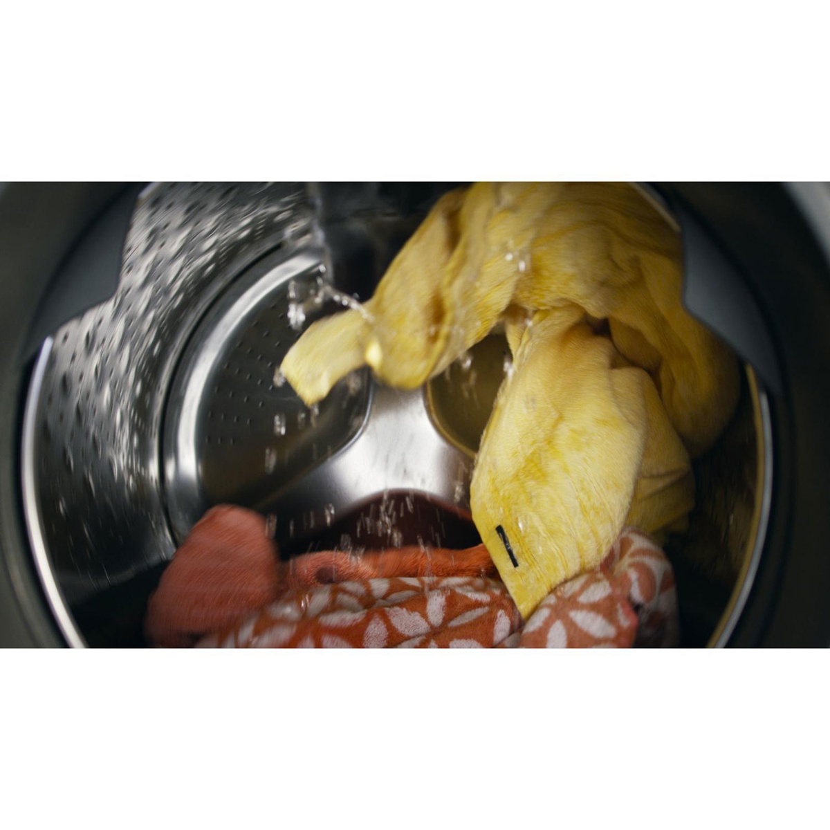 Inside the stainless steel wash basket with fabrics tumbling and water spray