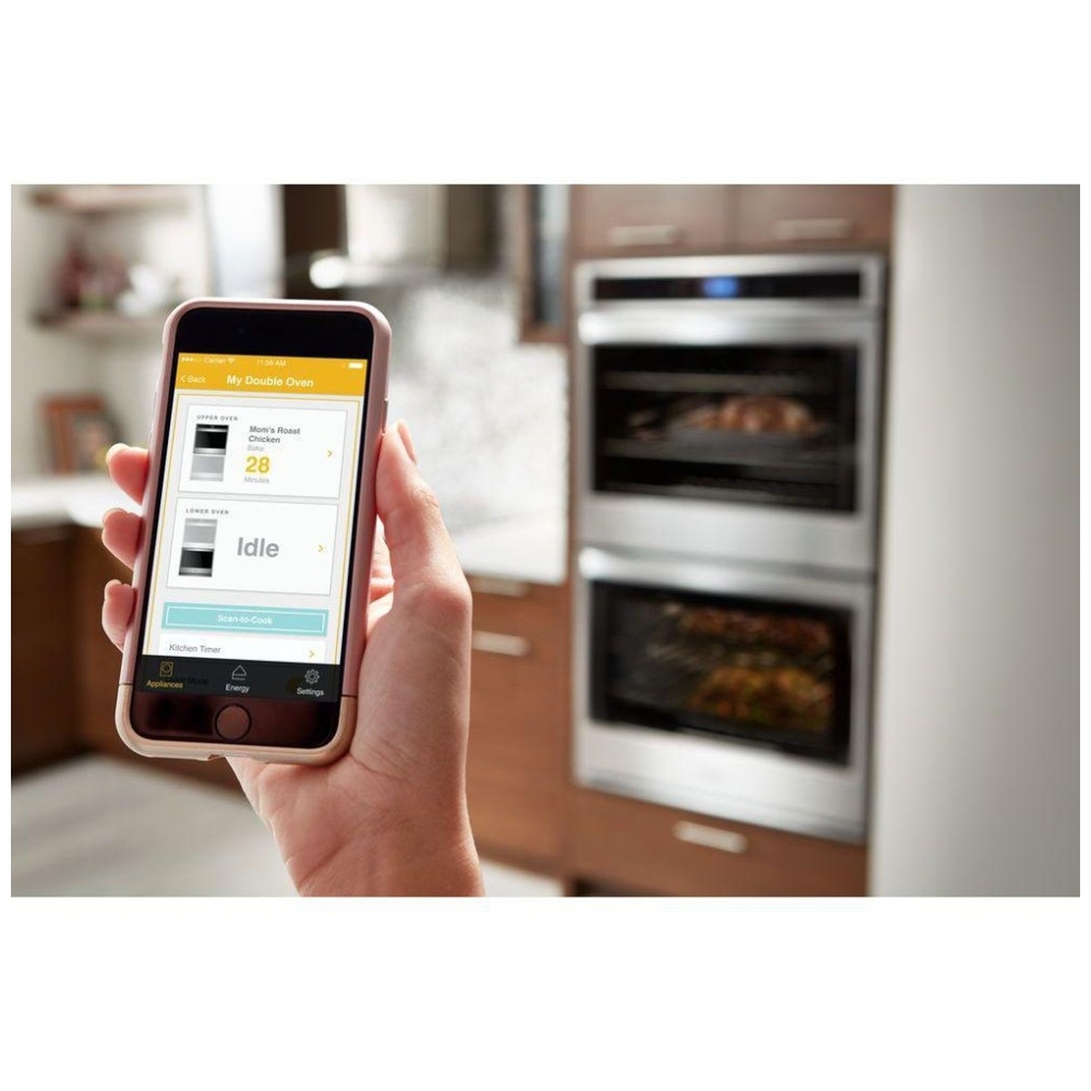 Hand holding smartphone with Whirlpool app controlling the double wall oven.