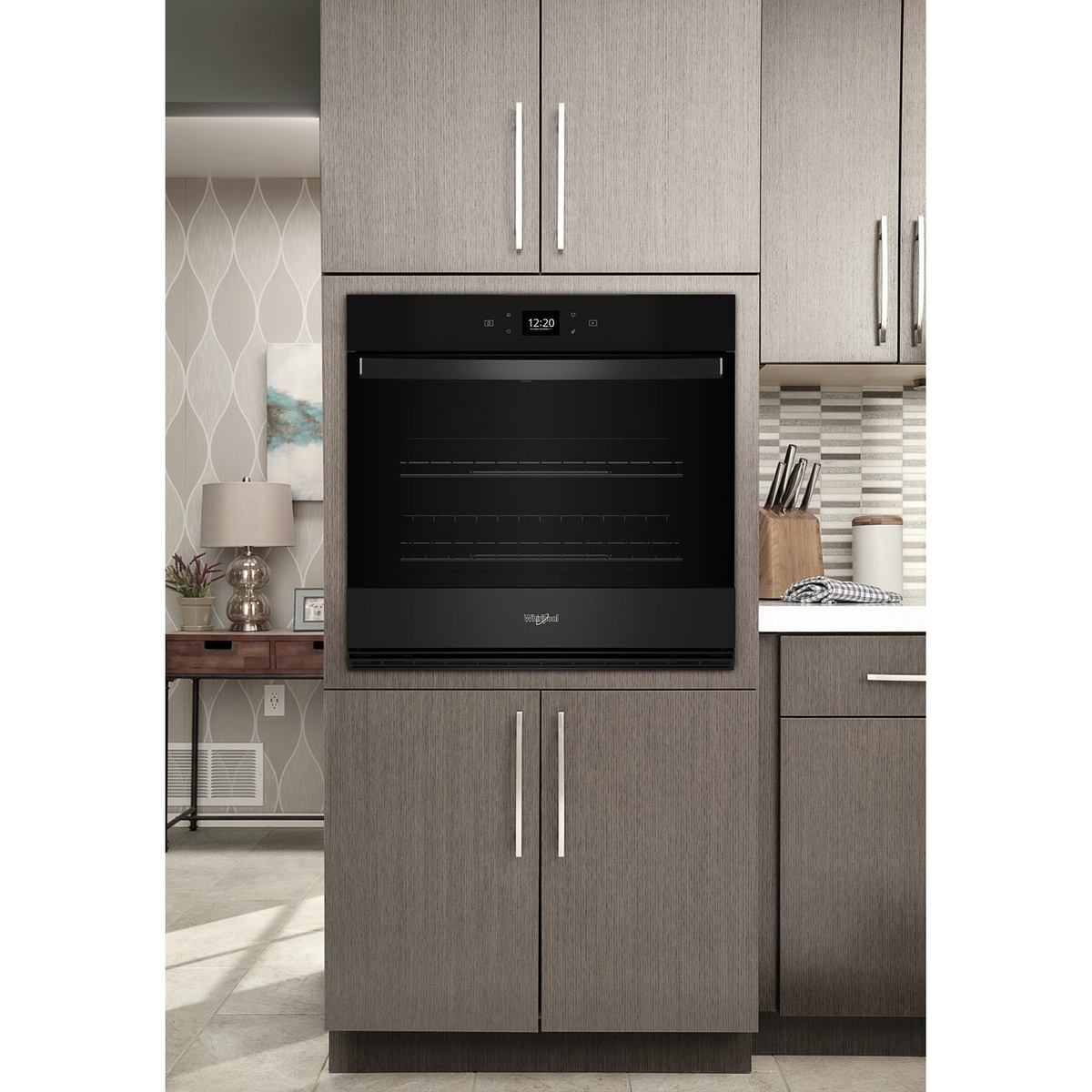 Black Whirlpool wall oven installed flush in modern cabinetry