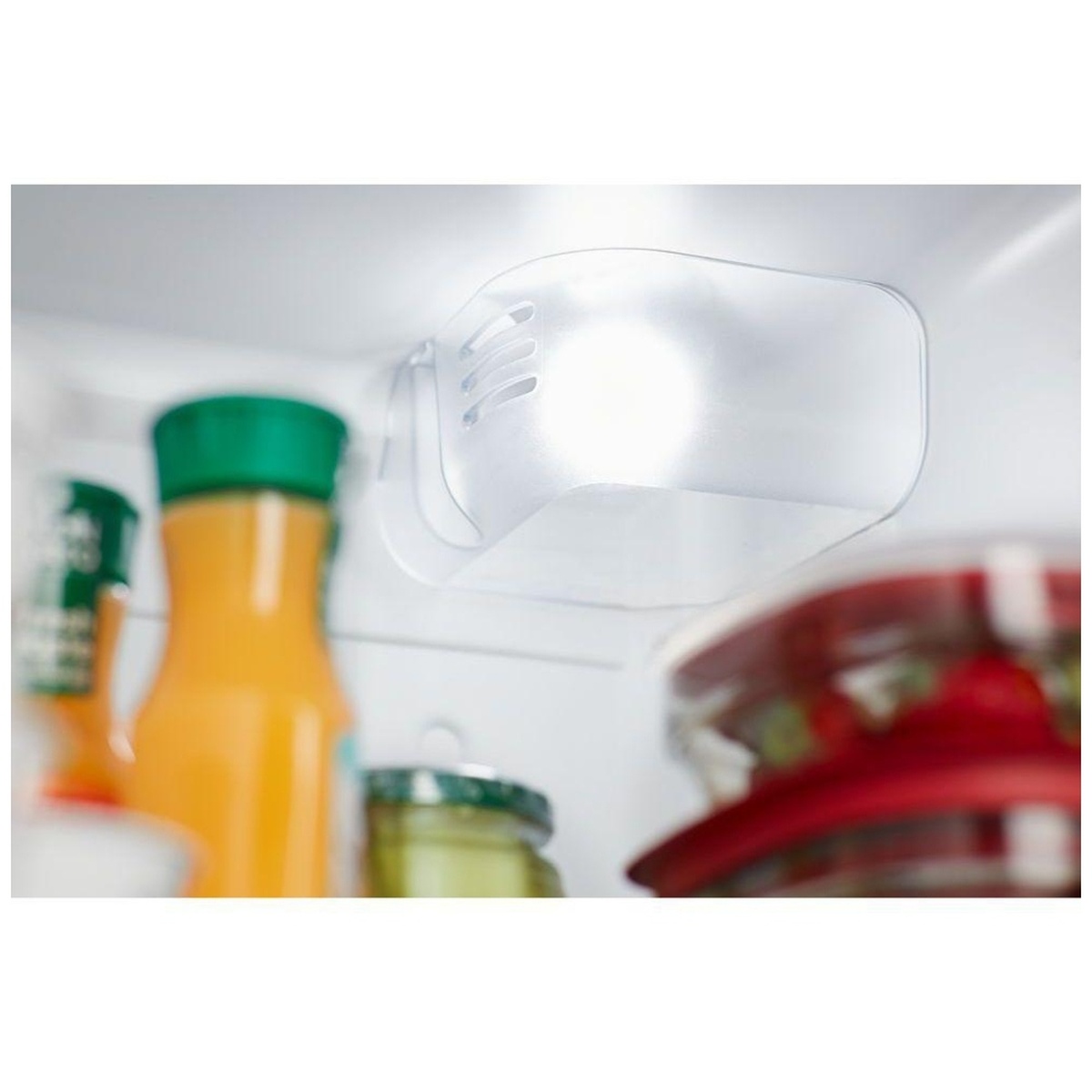 Close-up of the refrigerator's LED light illuminating items on the shelf.