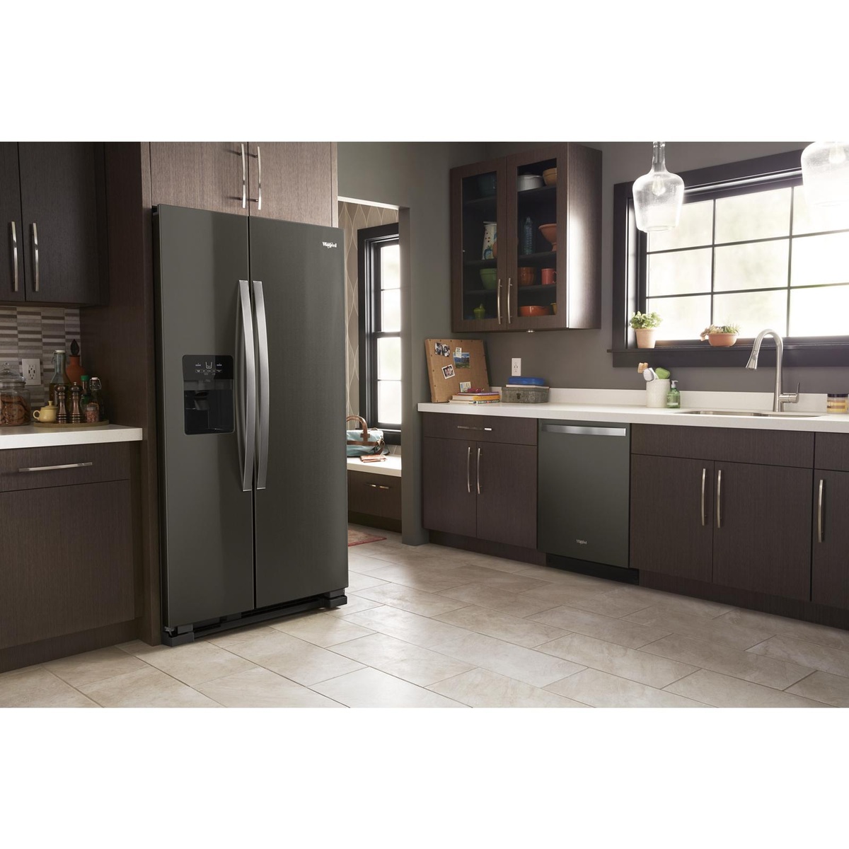 Whirlpool black stainless side-by-side refrigerator installed in a modern kitchen.