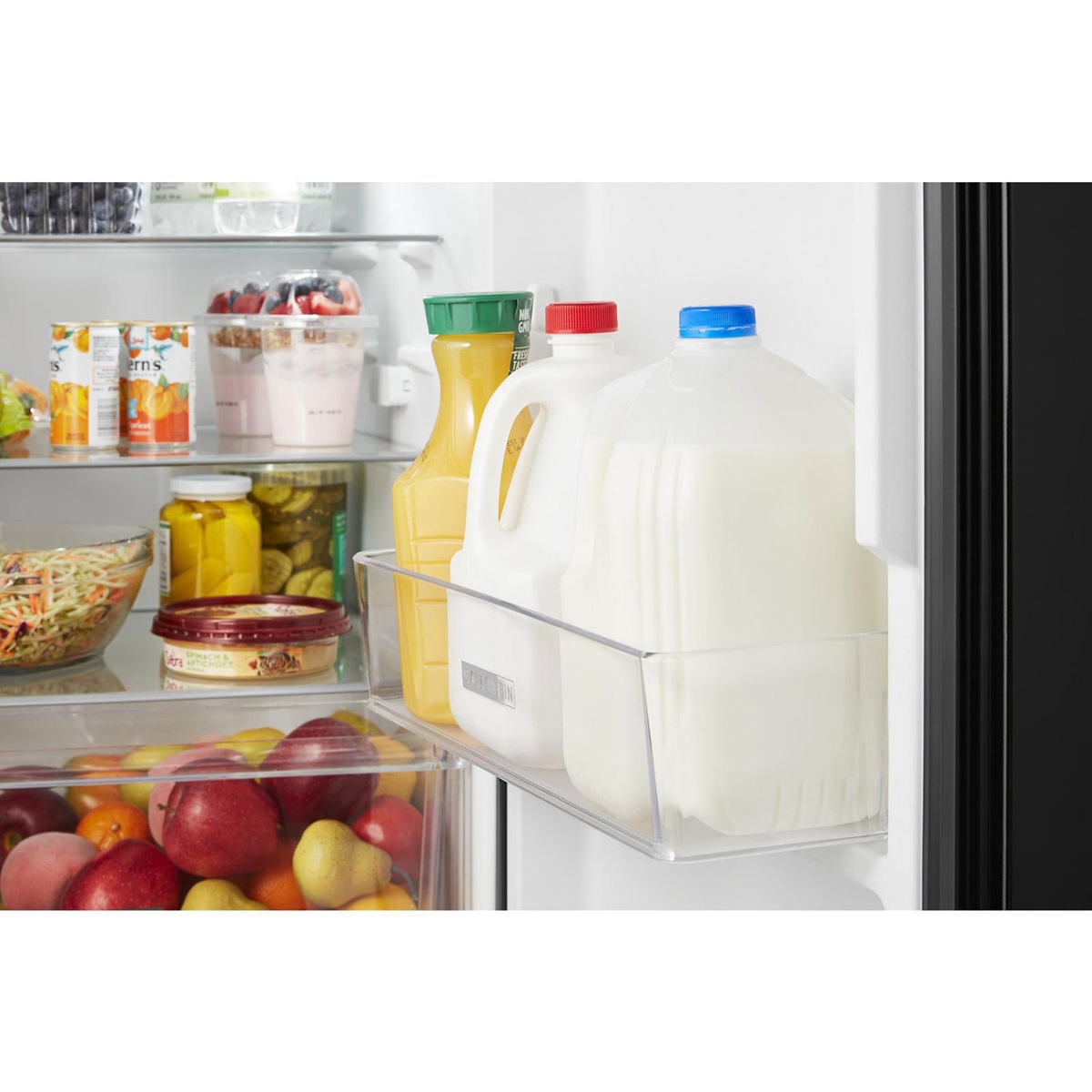 Gallon door bin holding milk and juice jugs