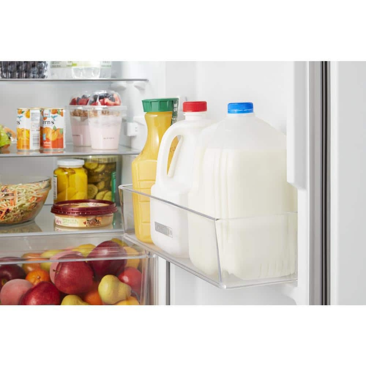 Close-up of gallon door bin holding milk and juice jugs.