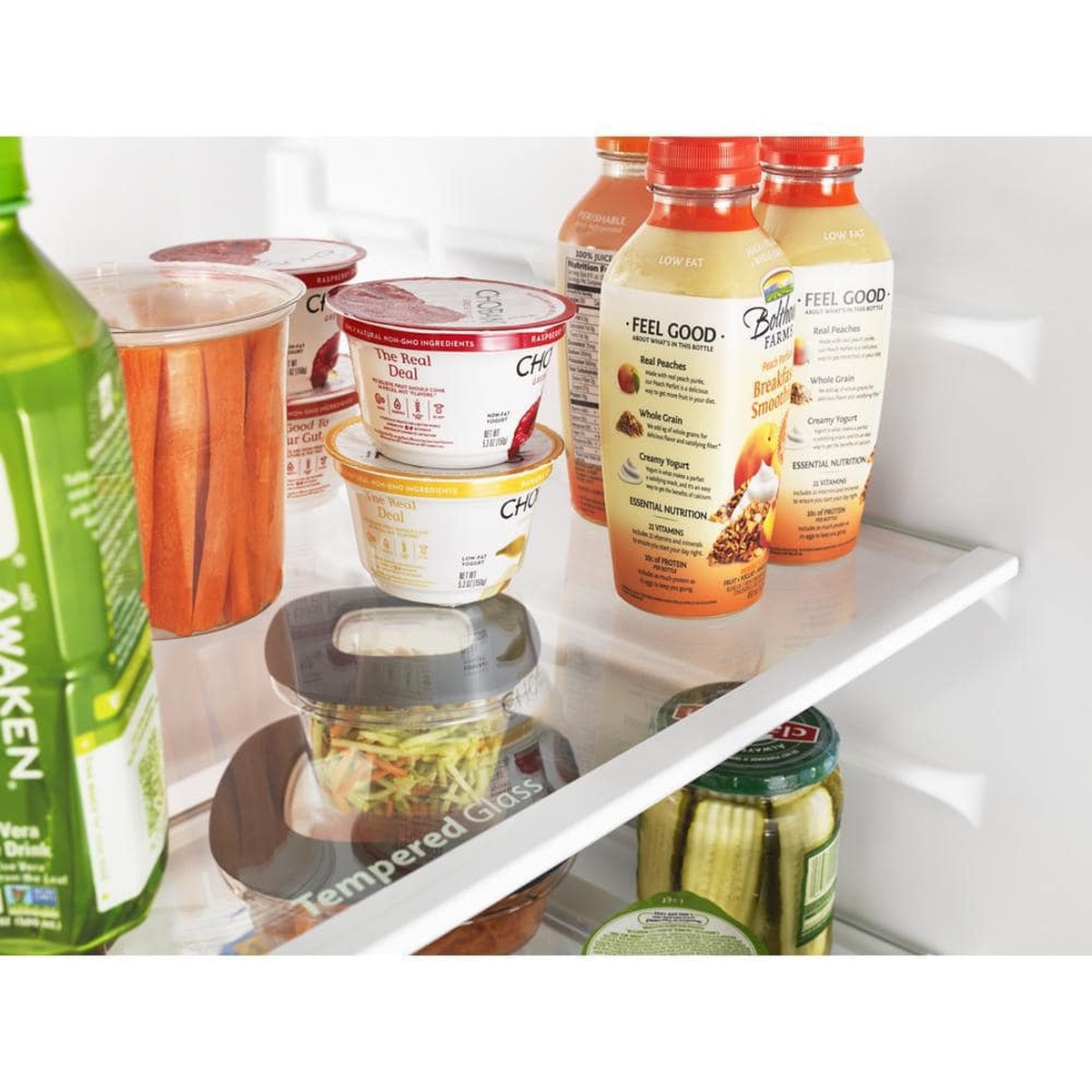 Close-up of frameless glass shelf holding yogurt and beverages.