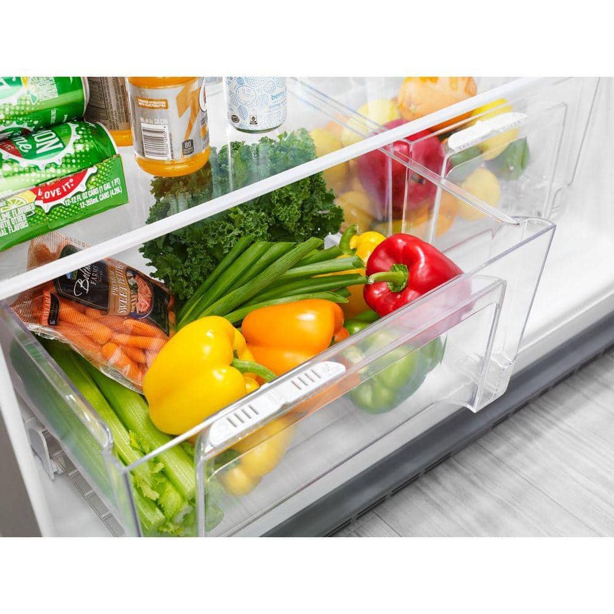 Close-up of twin humidity-controlled crisper drawers filled with produce