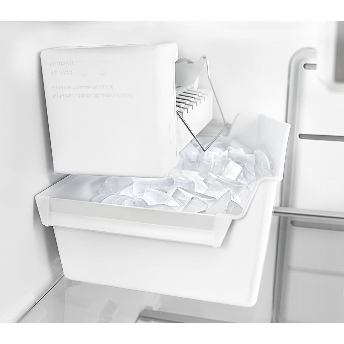 Close-up of optional icemaker producing fresh ice inside the freezer