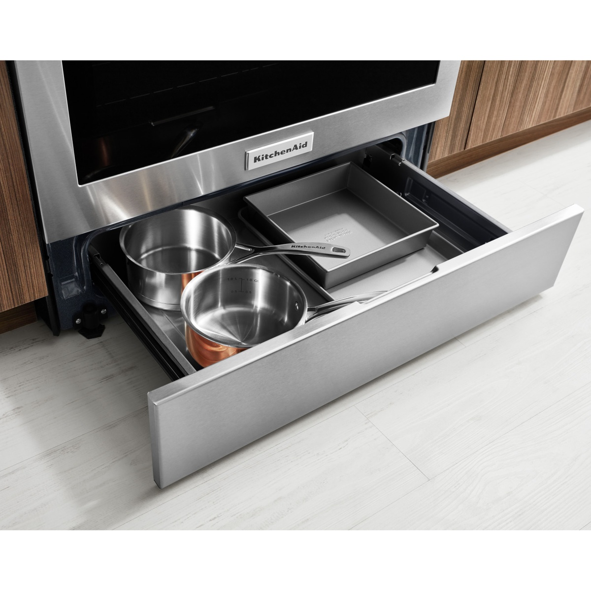 Range storage drawer pulled out holding pots and bakeware.