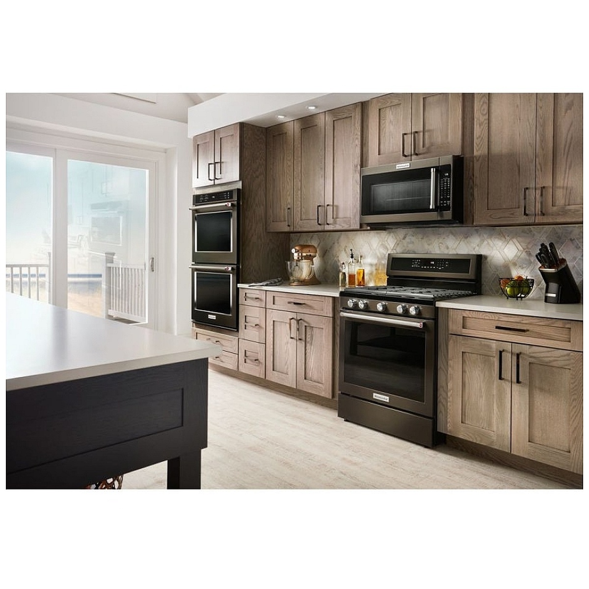 Kitchen installed with matching KitchenAid black stainless suite and over-the-range microwave above the range