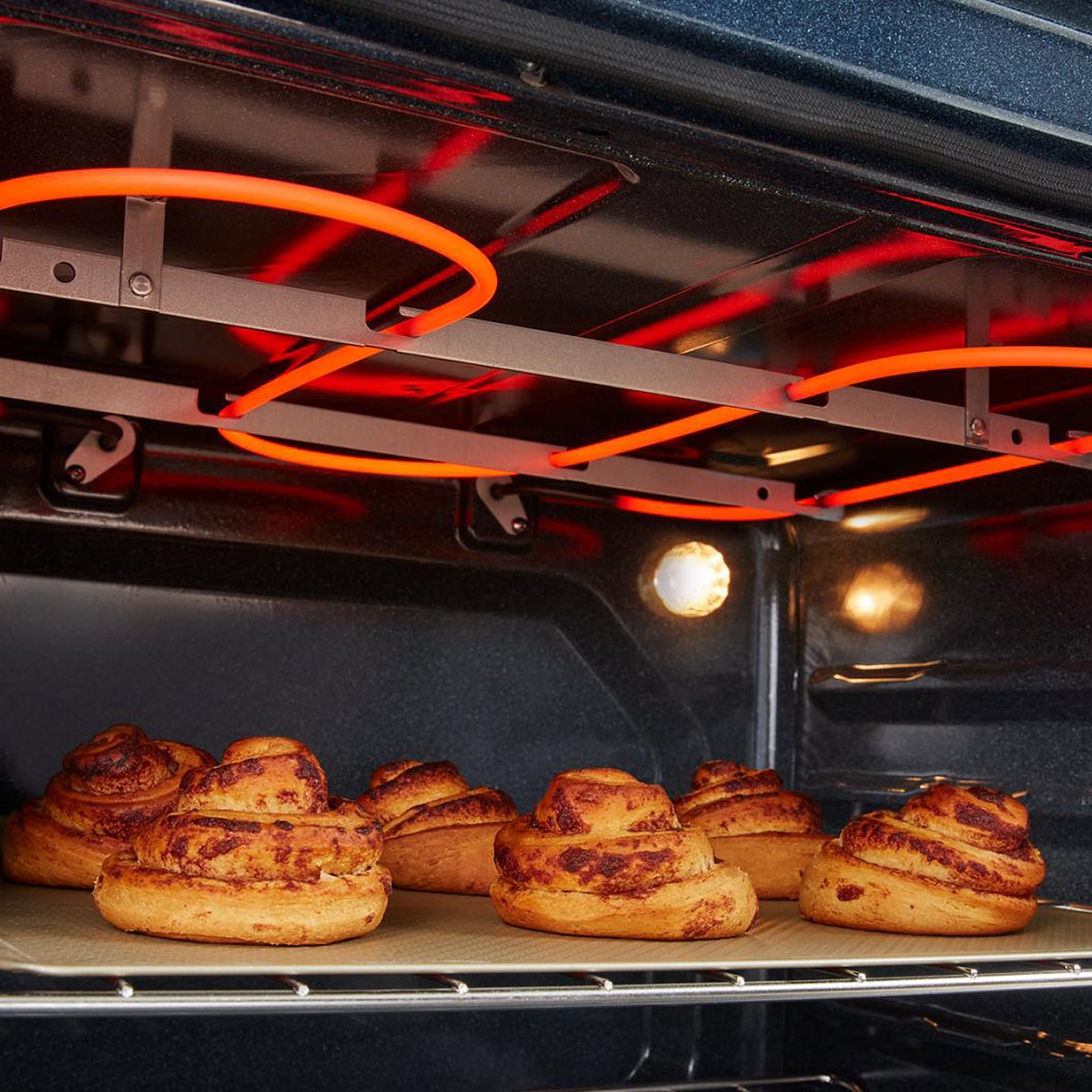 Close-up of glowing broil element browning pastries