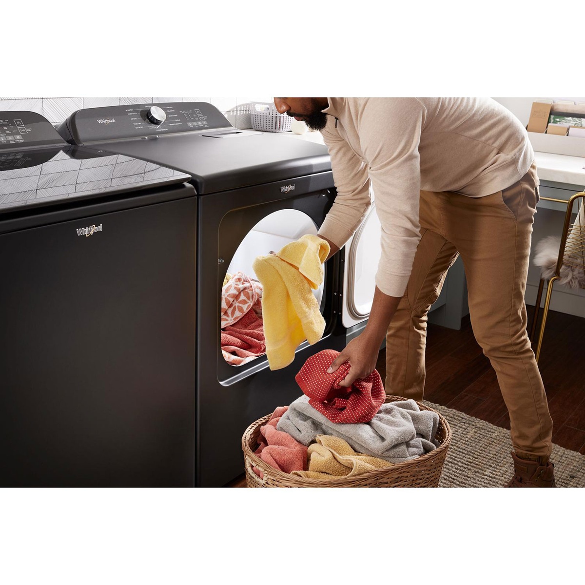 Lifestyle scene of user transferring laundry into the Whirlpool dryer