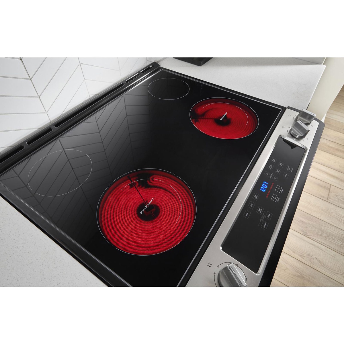 Radiant smooth-top cooktop with two glowing dual elements on a slide-in Whirlpool range.