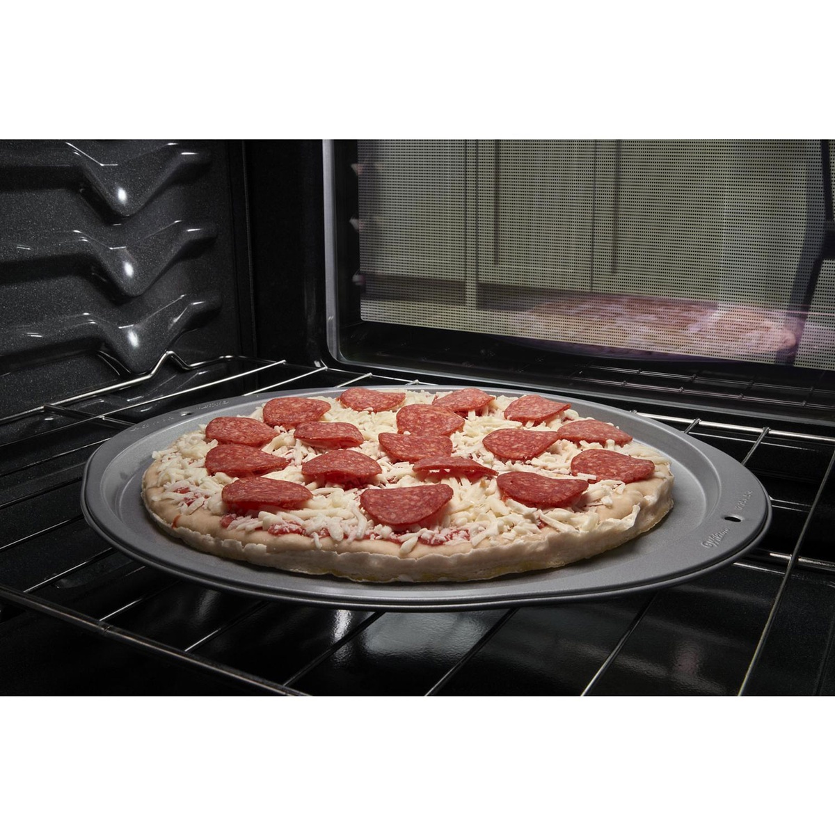 Frozen pizza on an oven rack using Frozen Bake preset inside the Whirlpool oven.