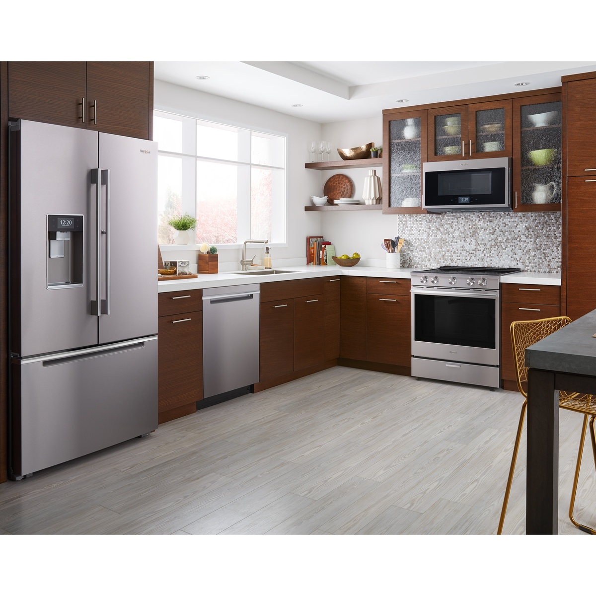 Modern kitchen showing the stainless steel Whirlpool slide-in range installed flush with countertops.