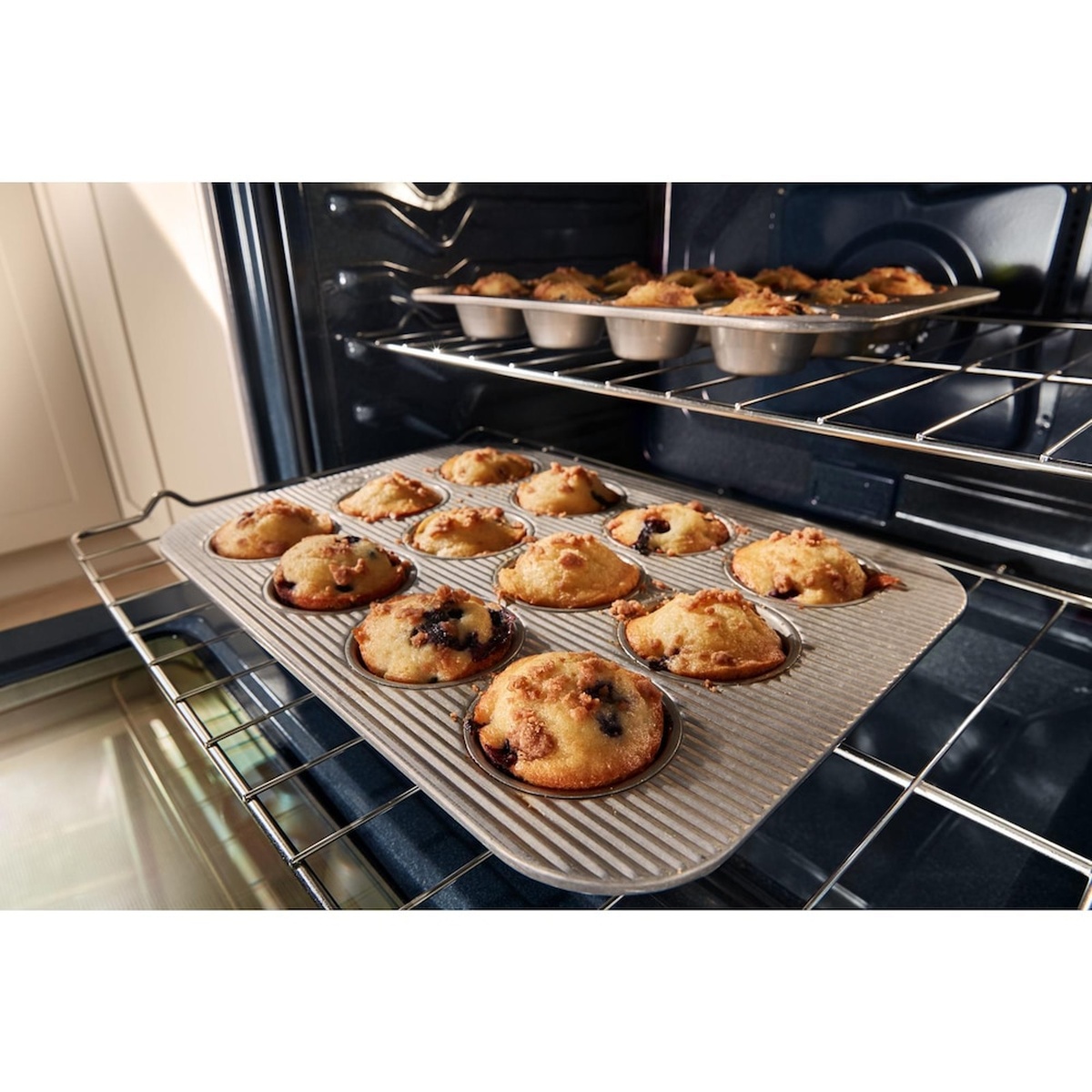 Two oven racks with muffins baking evenly using fan convection