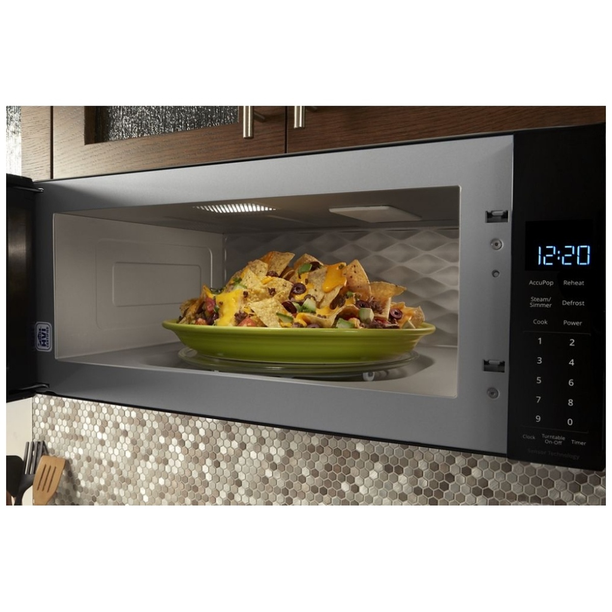 Microwave interior in use with a large plate of nachos and illuminated keypad