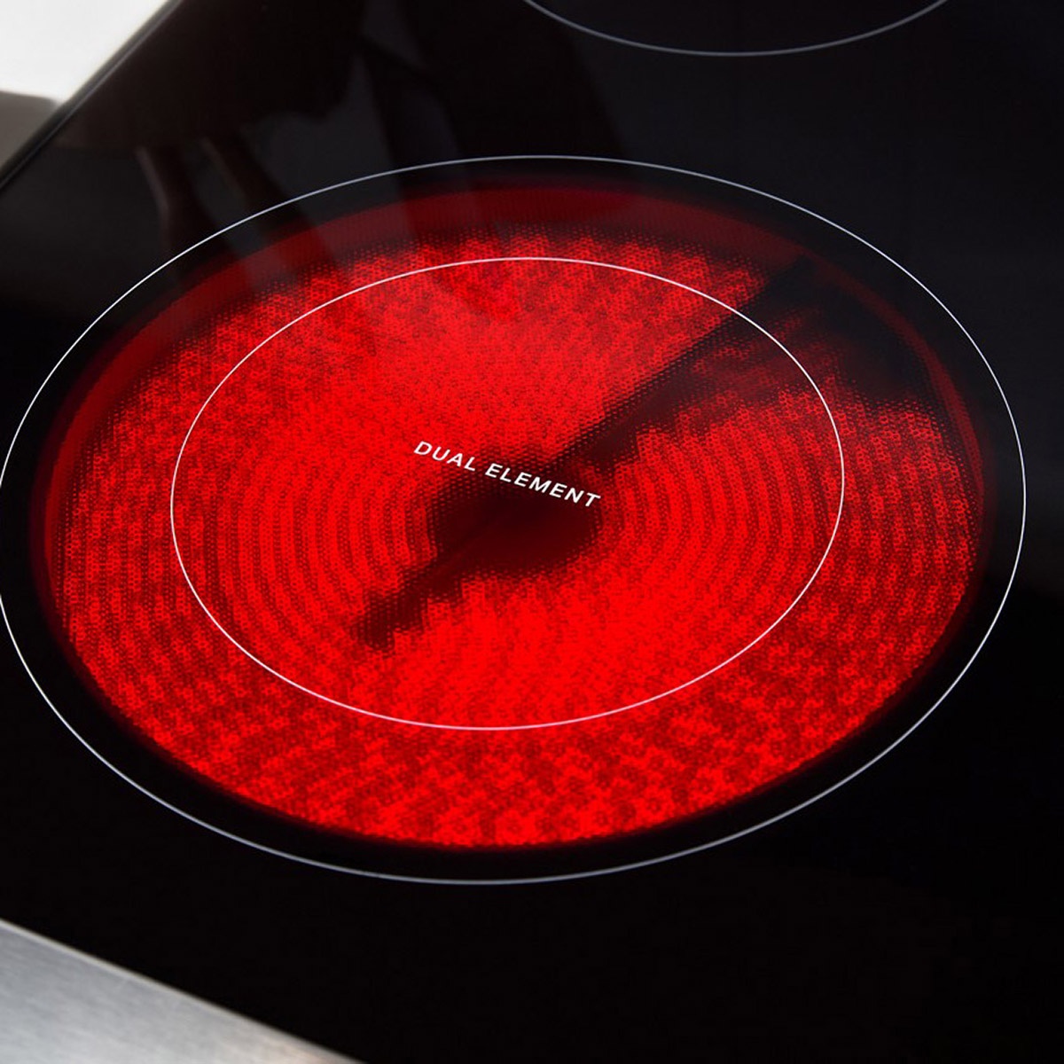 Close-up of a glowing dual radiant element on the smooth glass cooktop