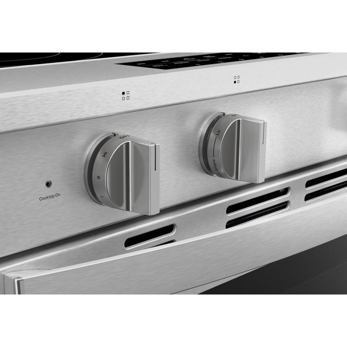 Close-up of durable stainless knobs and vent above the oven door.