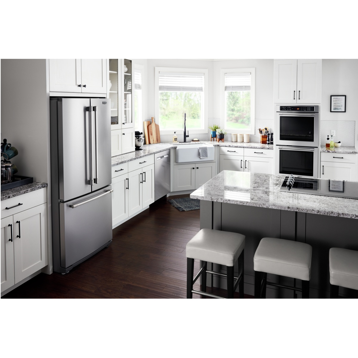 Maytag fingerprint resistant stainless French-door refrigerator installed in a bright white kitchen