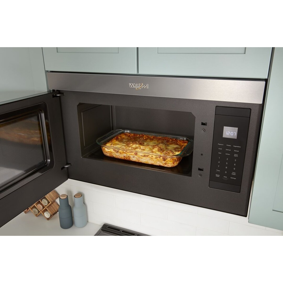 Whirlpool flush-mount microwave with the door open, showing a flat, turntable-free interior and a right-side touch control panel