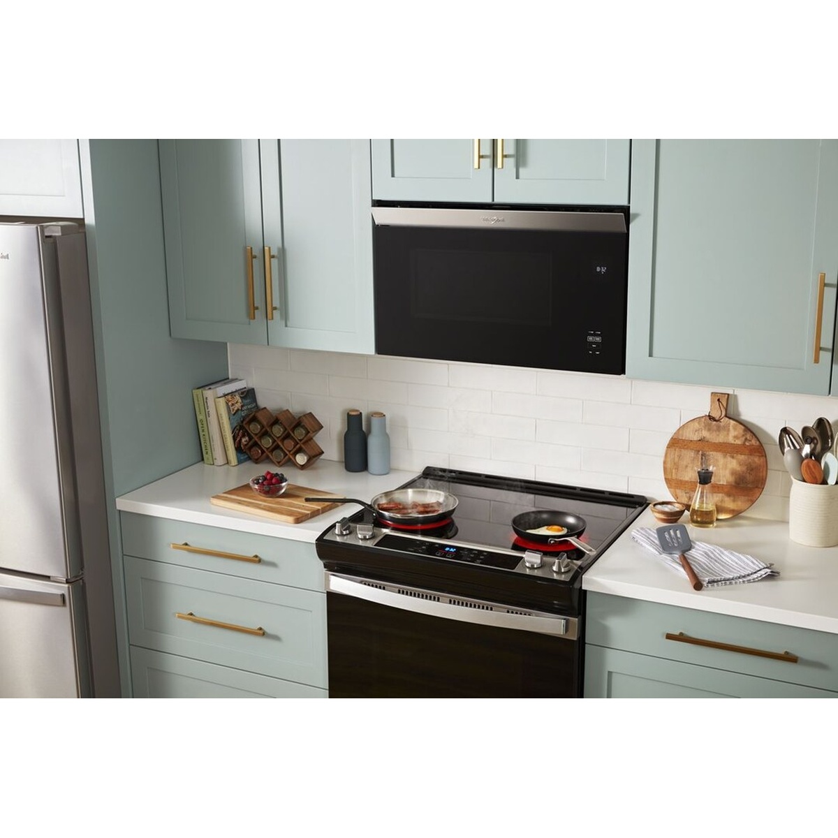 Whirlpool flush-mount microwave installed in upper cabinetry above a range in a modern kitchen
