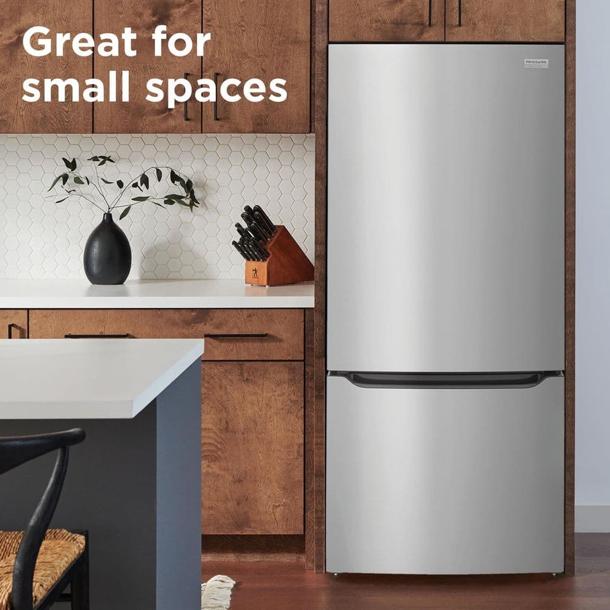 Frigidaire bottom-freezer refrigerator installed in a kitchen, shown fitting neatly into a compact cabinet opening with text reading ‘Great for small spaces’