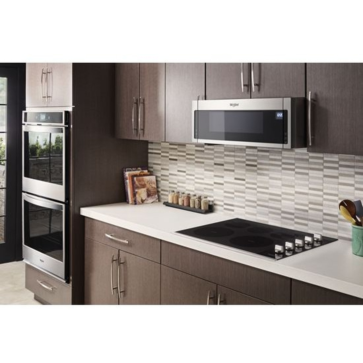 Kitchen scene with a built-in Whirlpool cooktop installed in a countertop alongside matching built-in appliances.