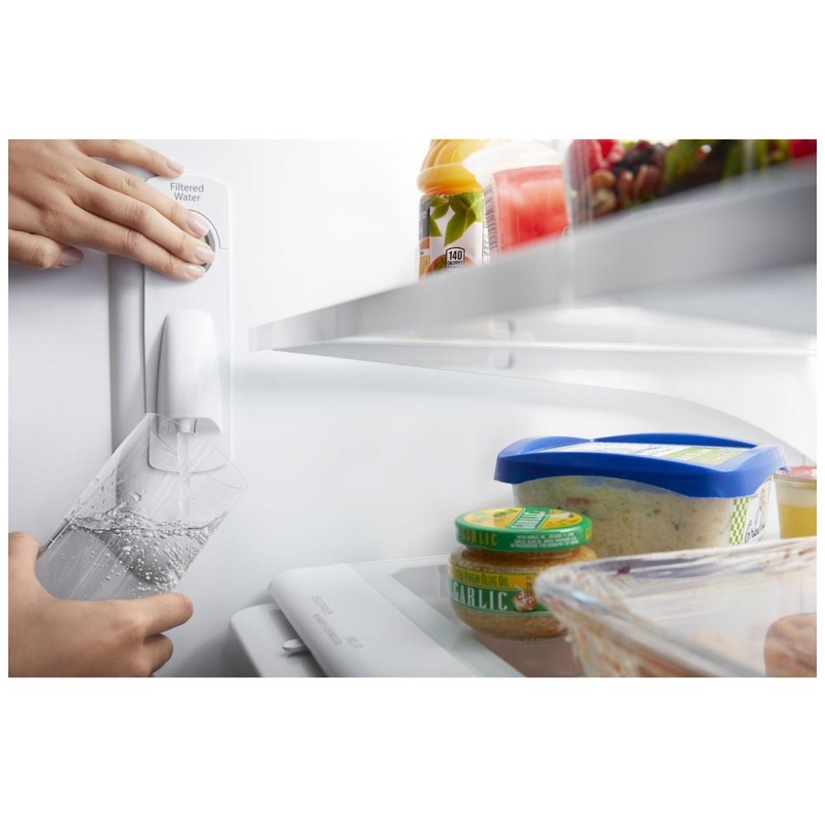 Hand filling a glass at the refrigerator's interior filtered water dispenser
