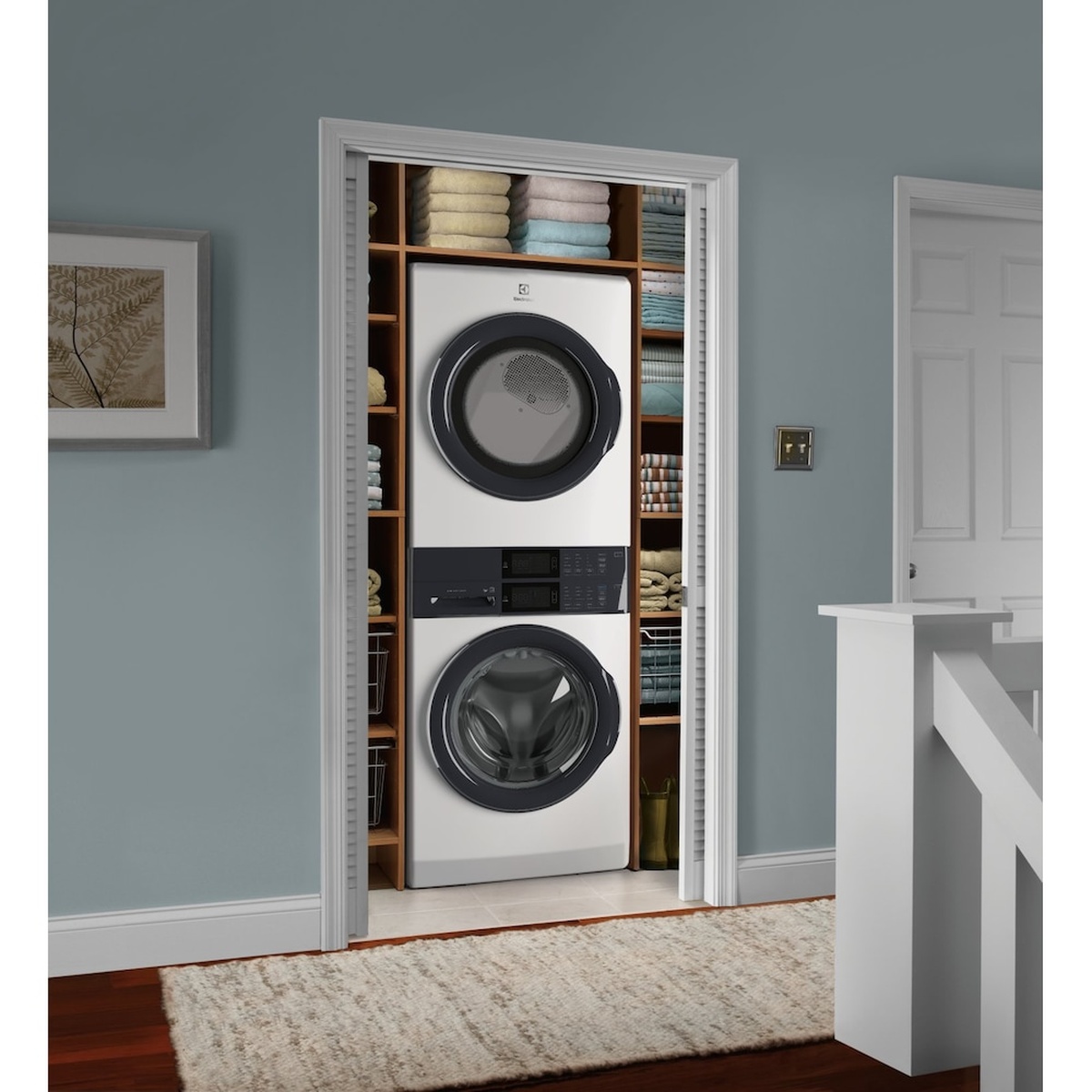 Electrolux Laundry Tower installed in a closet with built-in shelving and folded towels