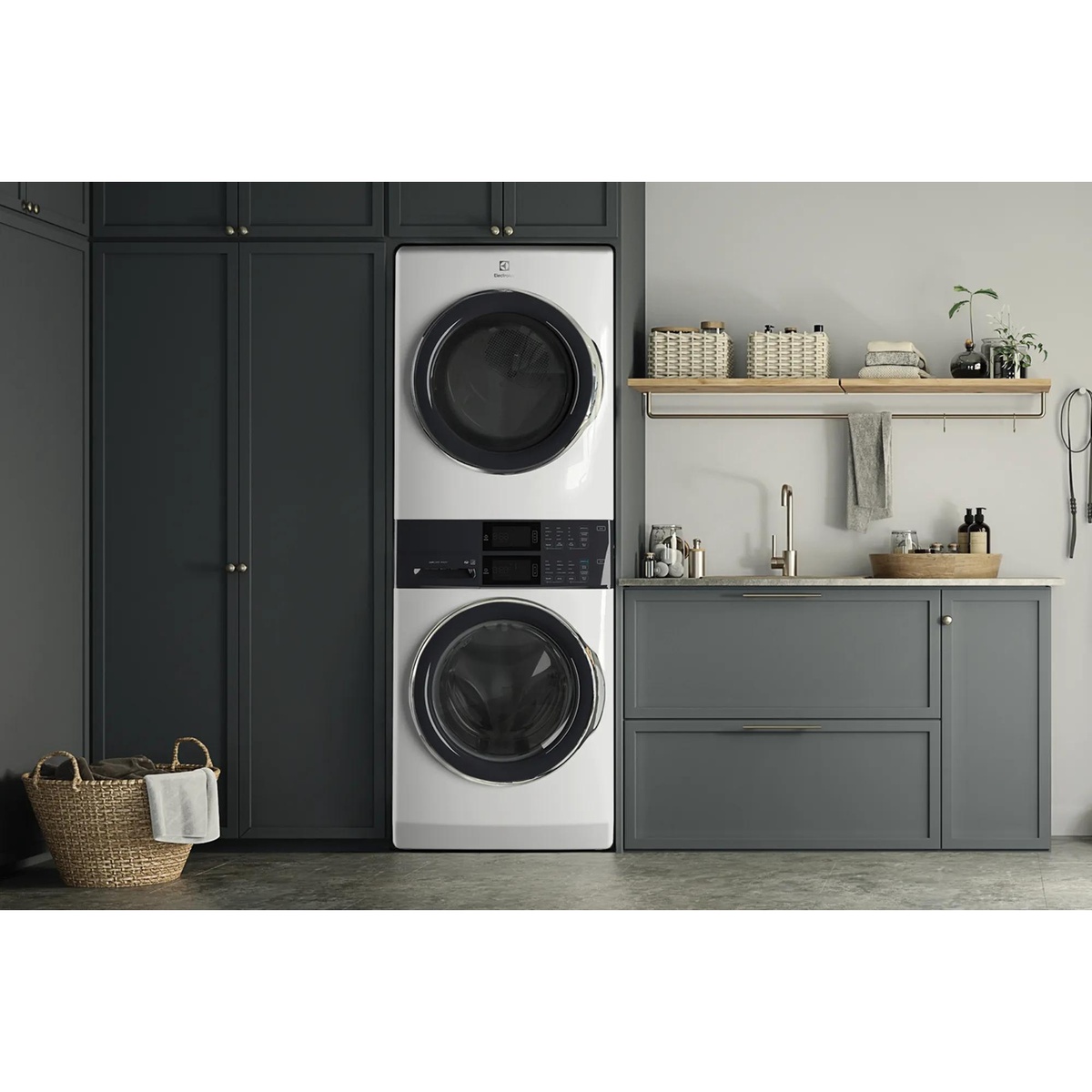 White Electrolux laundry tower installed between dark cabinets in a modern laundry room with a sink and countertop