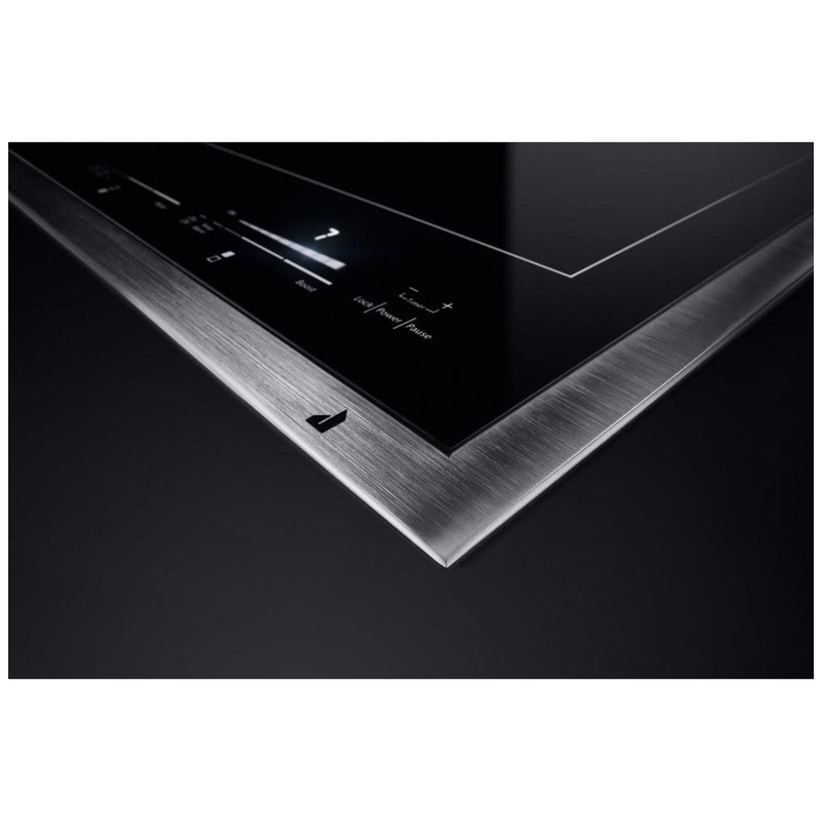Angled view of the cooktop corner showing the brushed metal frame around the black glass surface