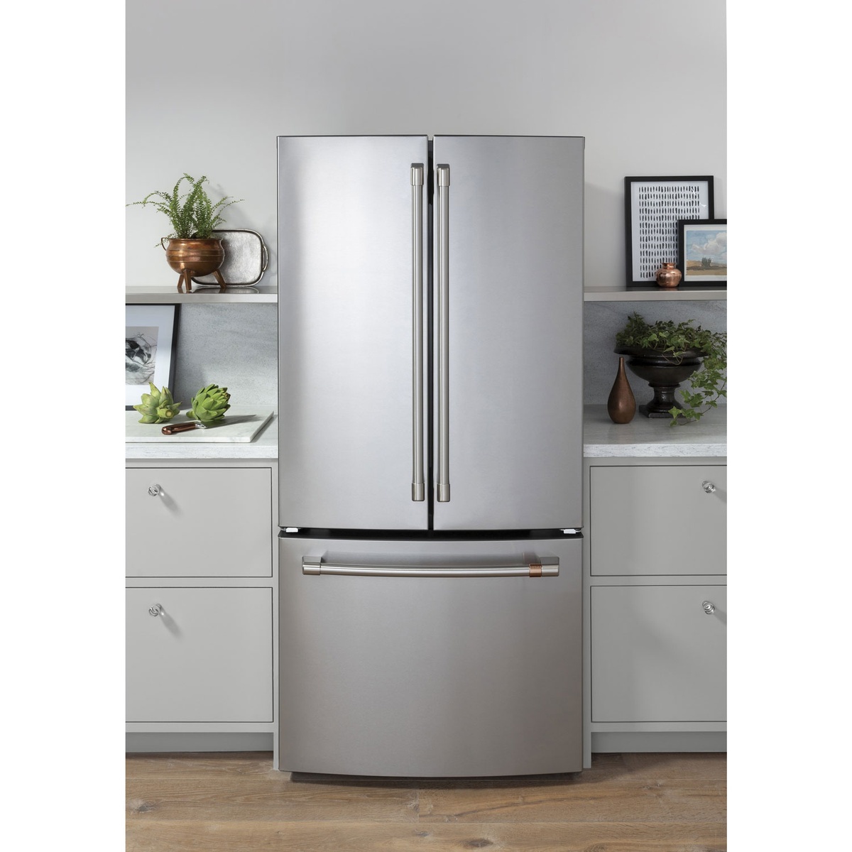 Café stainless steel counter-depth French door refrigerator installed between kitchen cabinets
