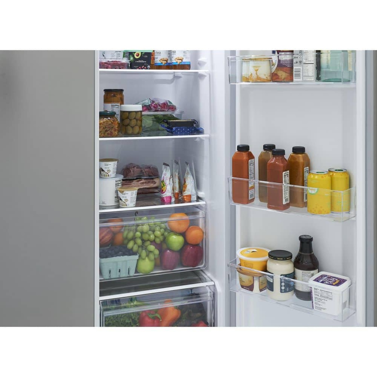 Open refrigerator compartment showing glass shelves, door bins, and clear produce drawers with food inside