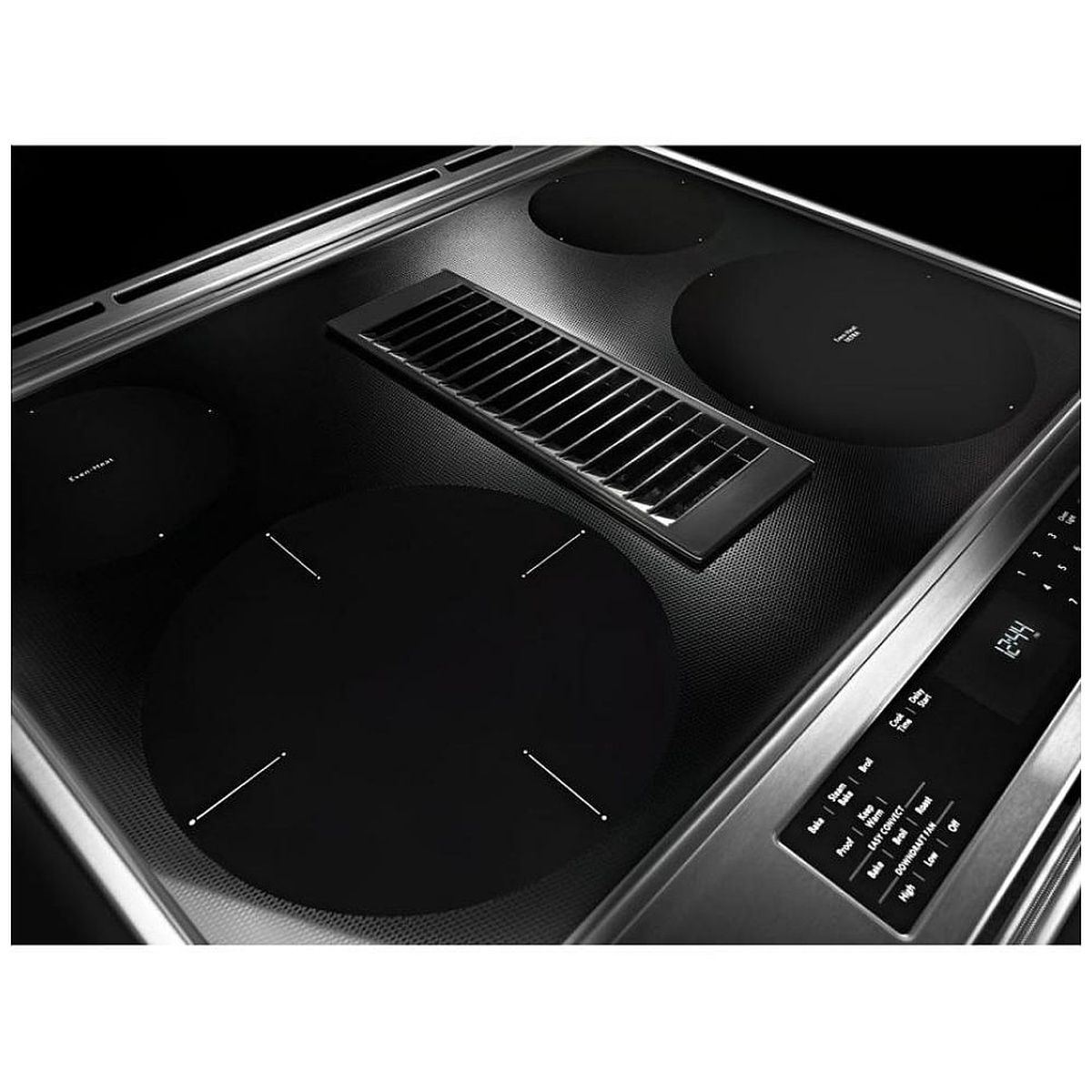 Angled close-up of the smooth black ceramic-glass cooktop showing four radiant elements, a center downdraft vent, and a touch control panel