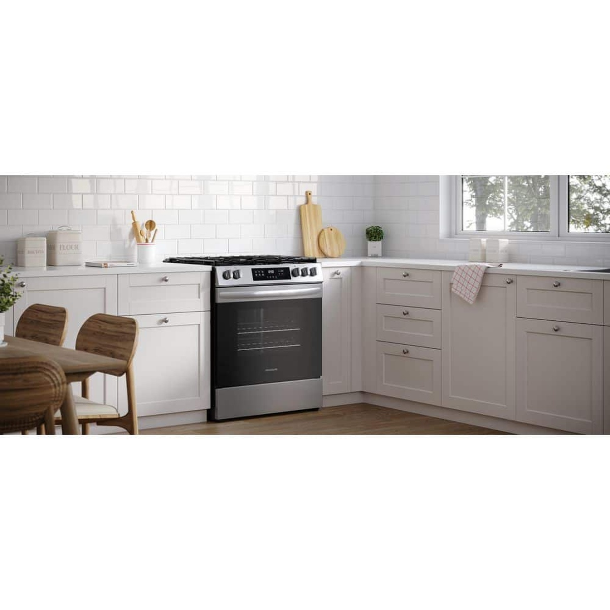 Frigidaire stainless steel gas range installed in a bright kitchen with light cabinetry and a window