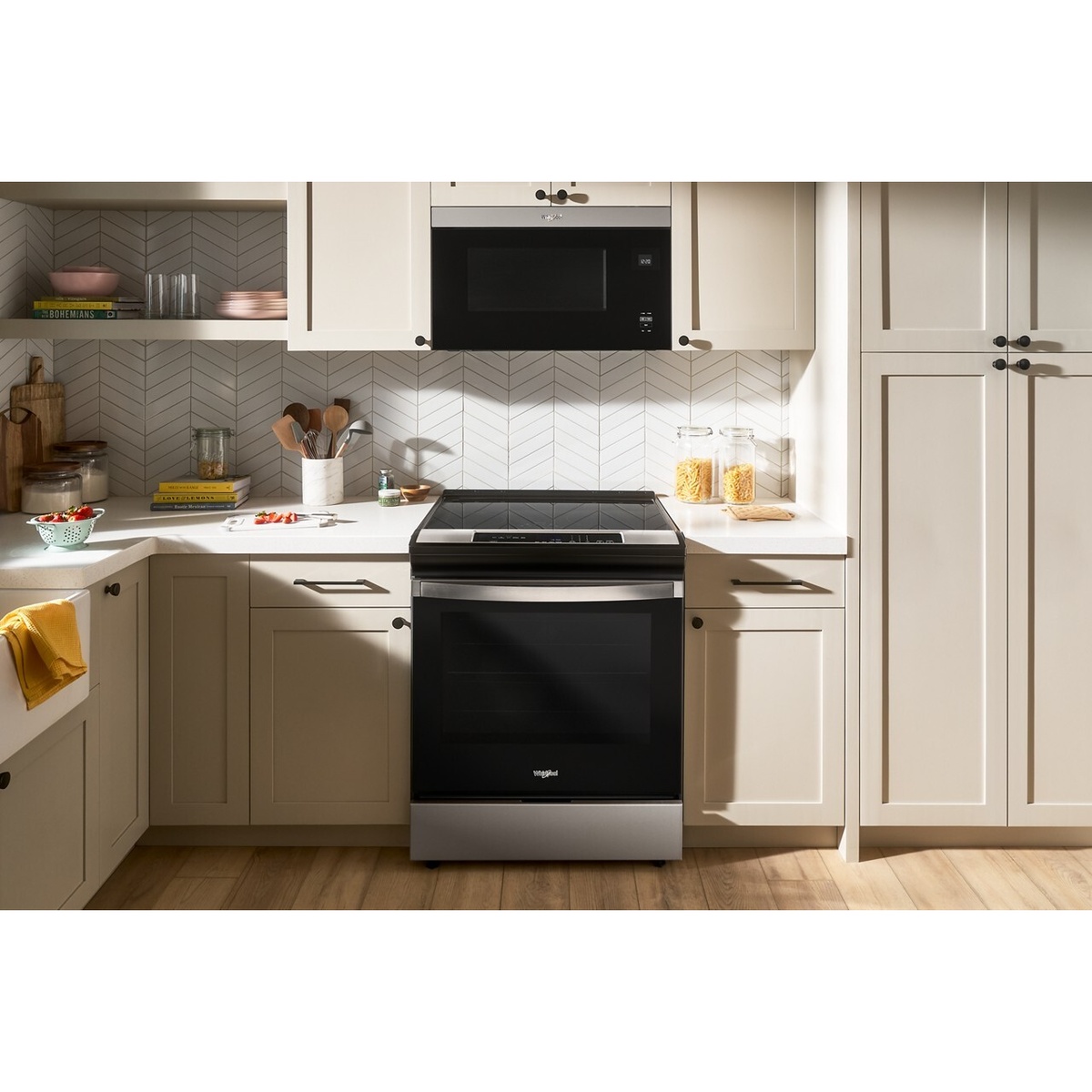 Whirlpool slide-in range installed between cabinets in a modern kitchen