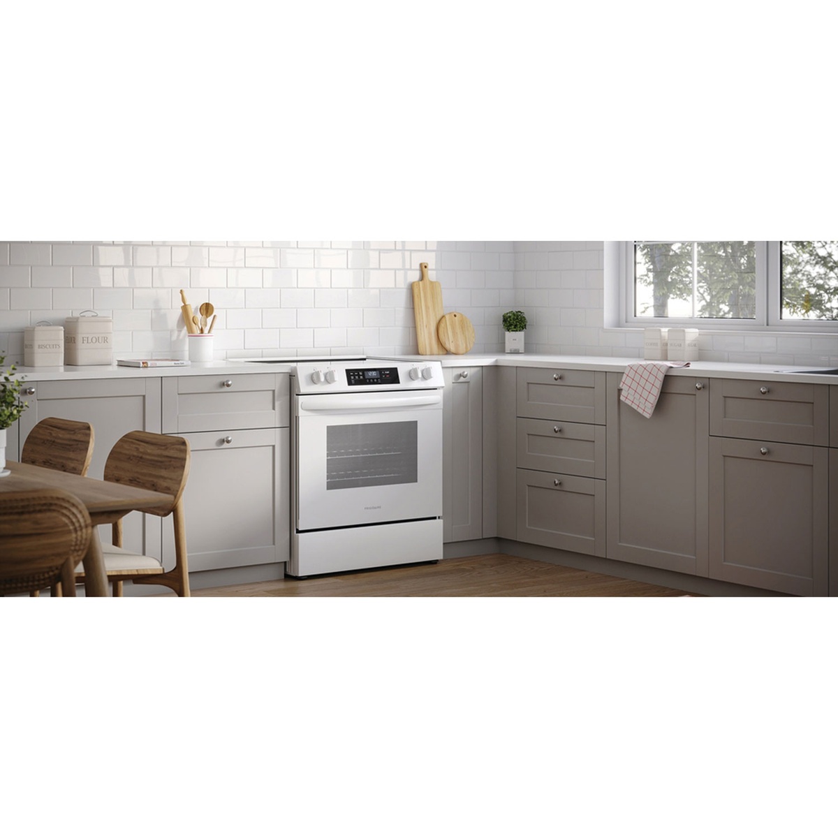 White Frigidaire freestanding electric range installed between kitchen cabinets with a tile backsplash