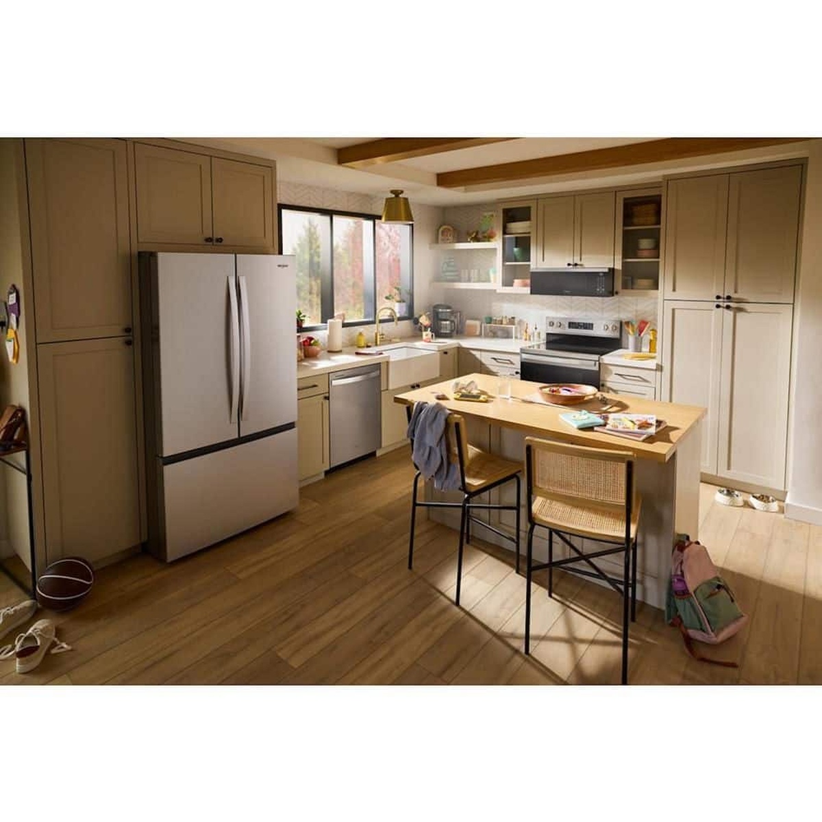 French door refrigerator shown in a bright kitchen next to cabinetry and an island