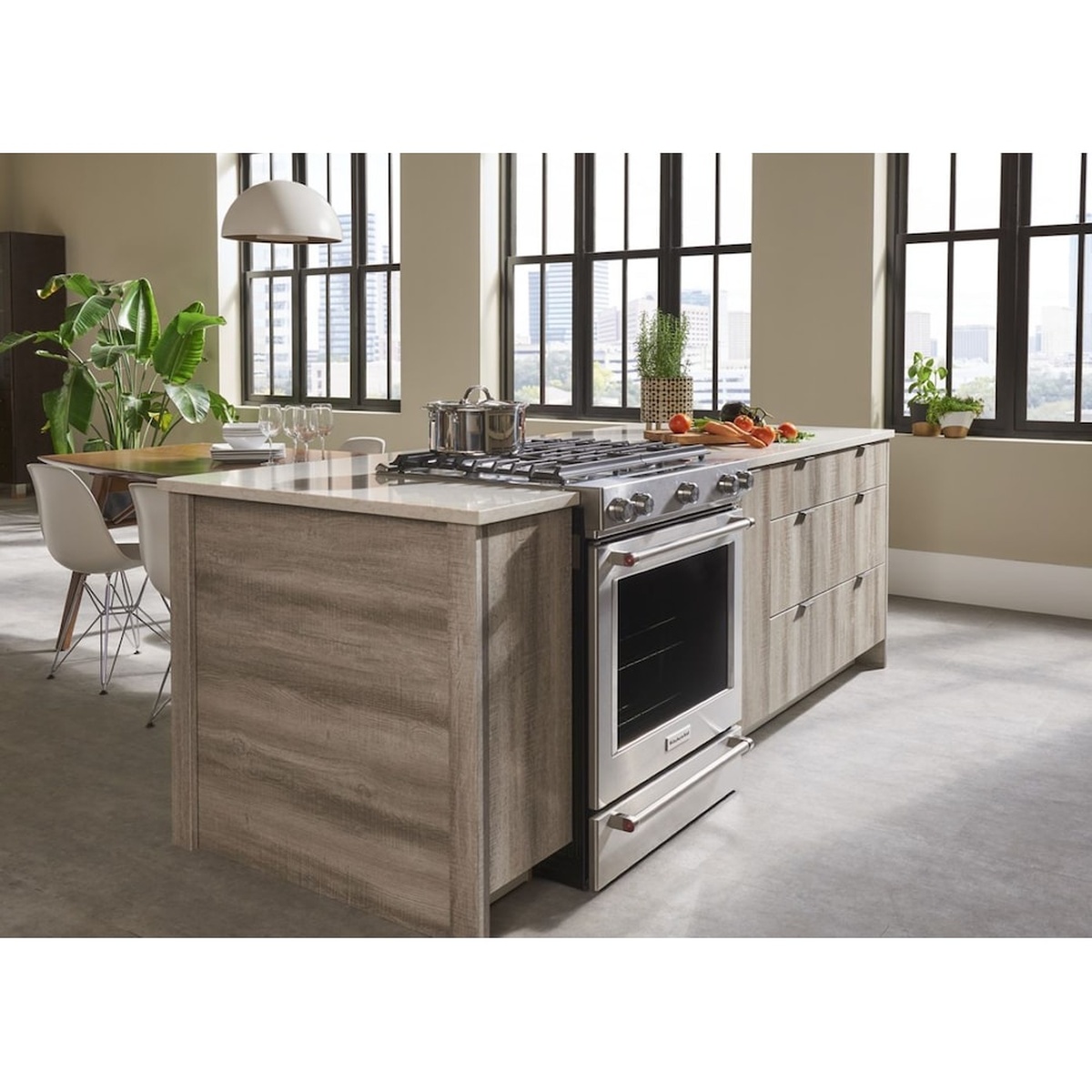 KitchenAid slide-in range installed in a modern kitchen island with large windows