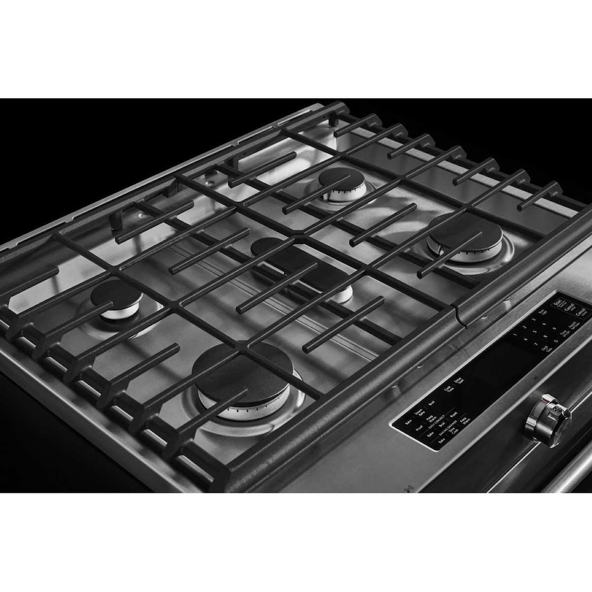 Close-up of the KitchenAid gas cooktop with continuous grates, five burners, and a front control panel