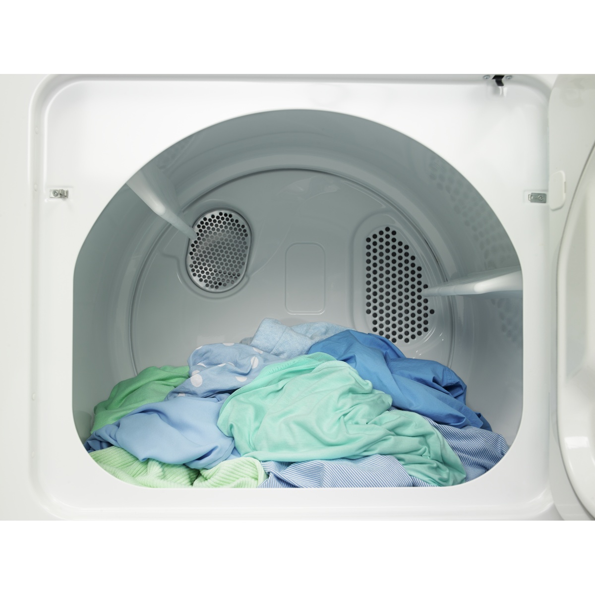 View into the open dryer drum with a mixed load of clothing inside