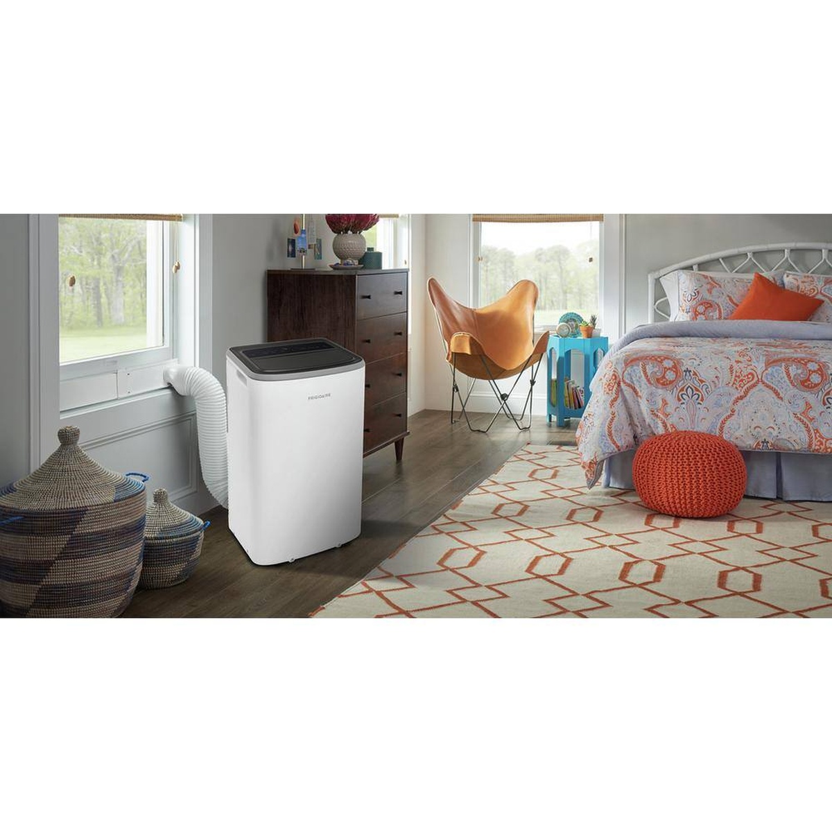 Frigidaire portable air conditioner installed in a bedroom with a single exhaust hose vented through a nearby window