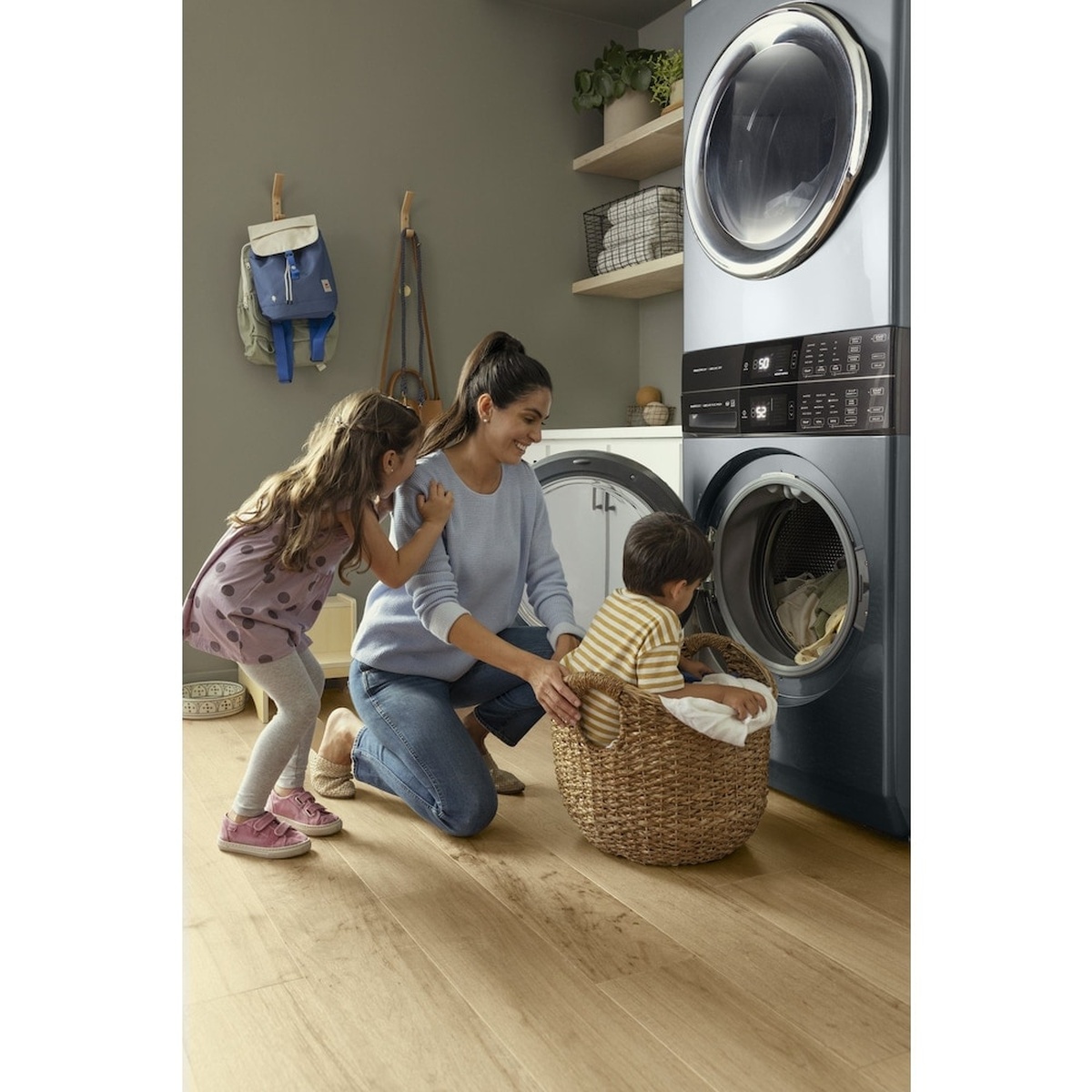 Electrolux stacked laundry tower in a home laundry room with a family loading laundry