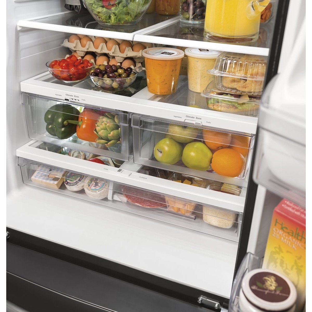 Close-up of the refrigerator interior showing clear crisper drawers and food stored on glass shelves
