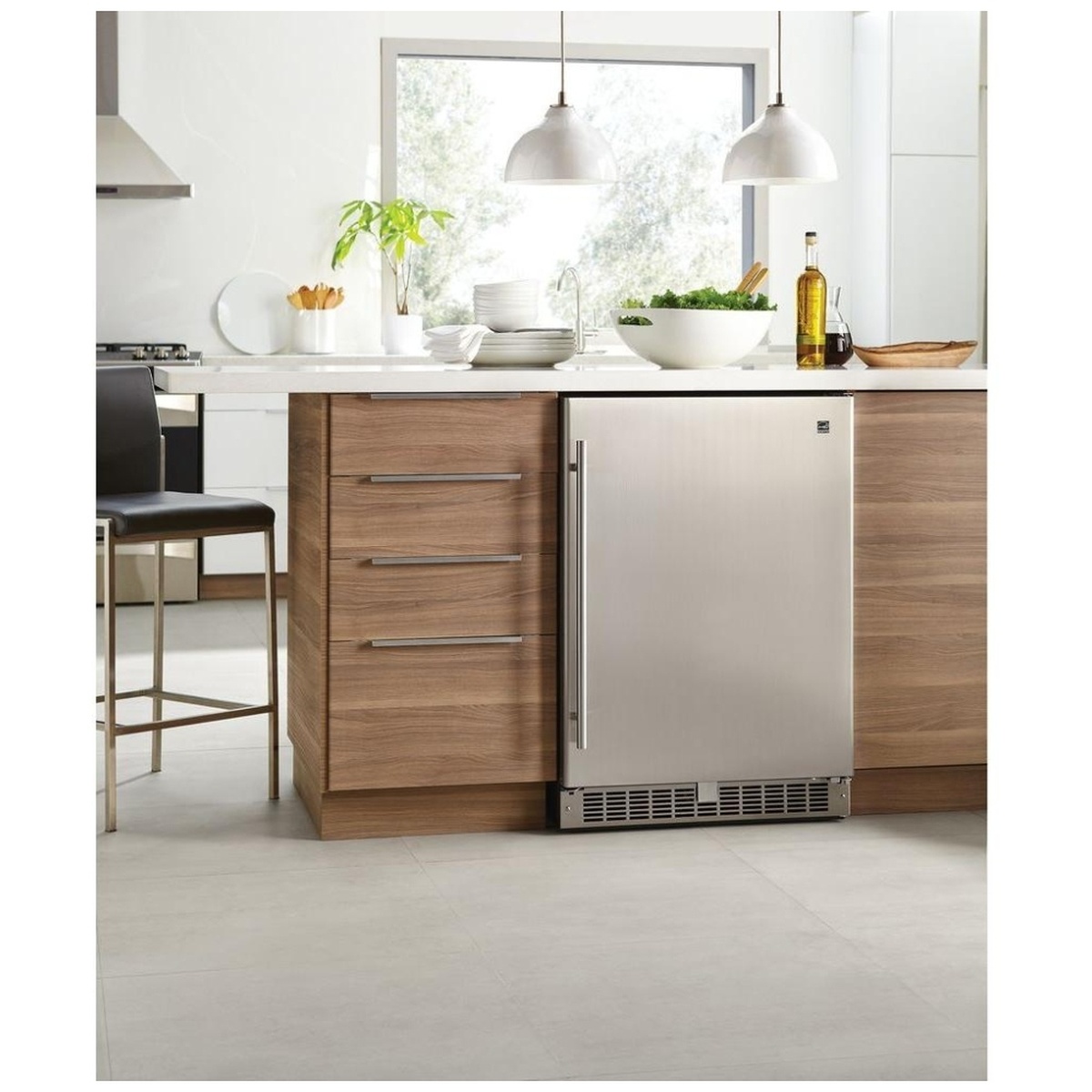 Silhouette stainless compact refrigerator installed under a kitchen counter next to wood cabinetry