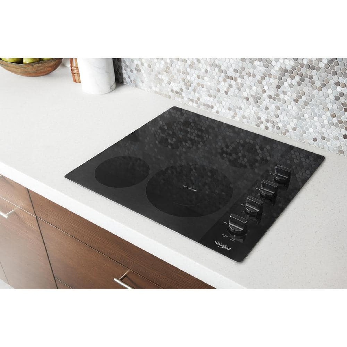 Whirlpool black smooth-top electric cooktop installed in a kitchen countertop with right-side knob controls