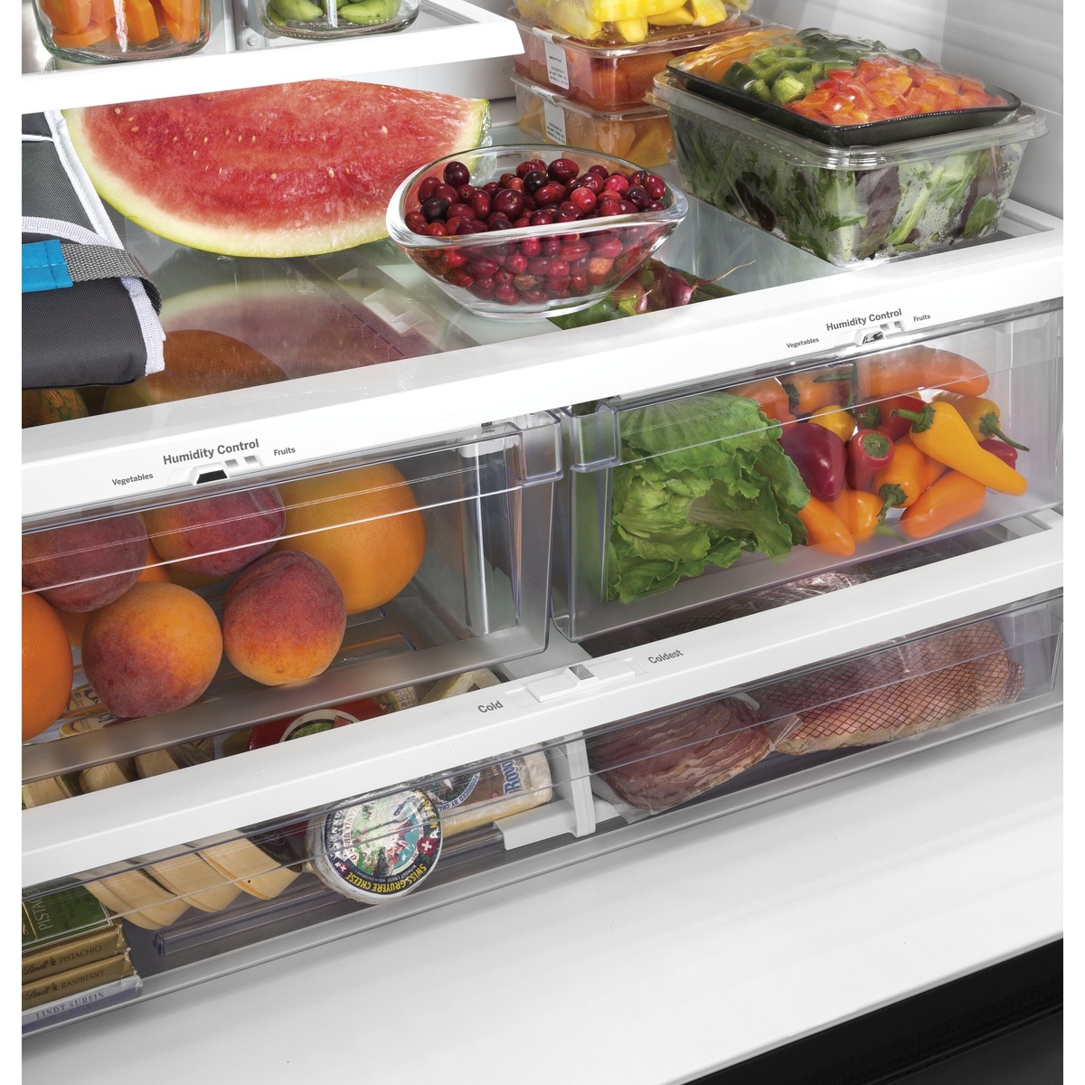 Close-up of the refrigerator interior drawers showing two clear humidity-controlled crispers and a full-width drawer with temperature selector