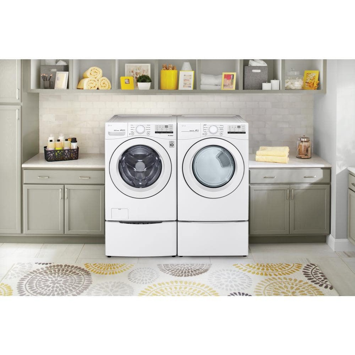 LG washer and matching LG dryer installed side by side in a home laundry room on pedestal drawers