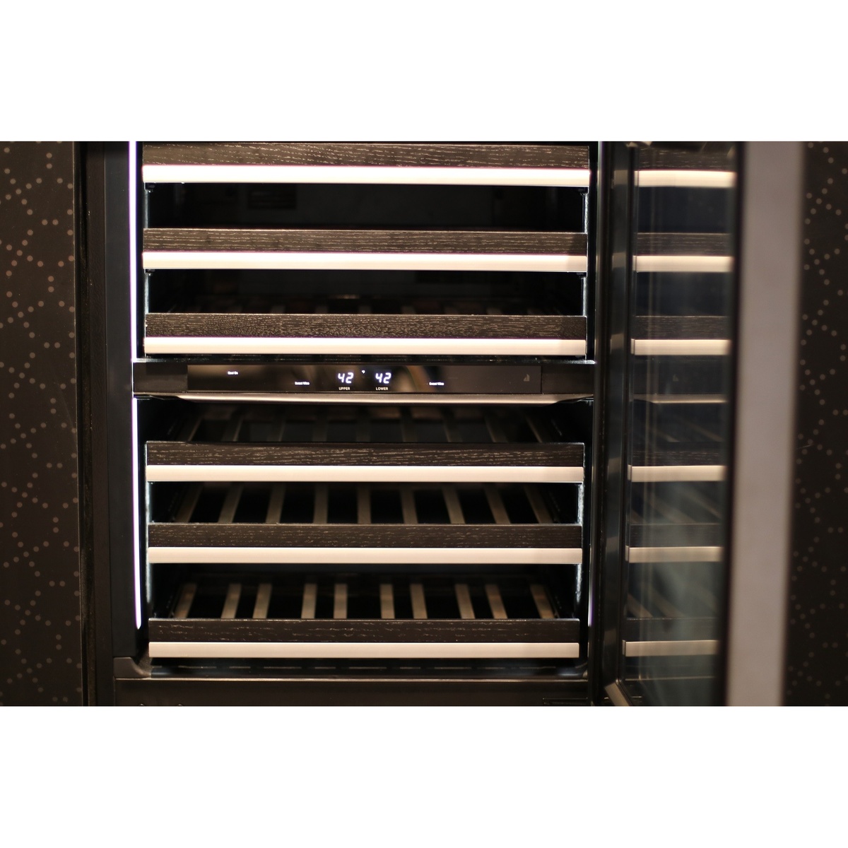 Interior view of the JennAir wine cooler showing wood racks, vertical LED lighting, and a digital temperature display for upper and lower zones
